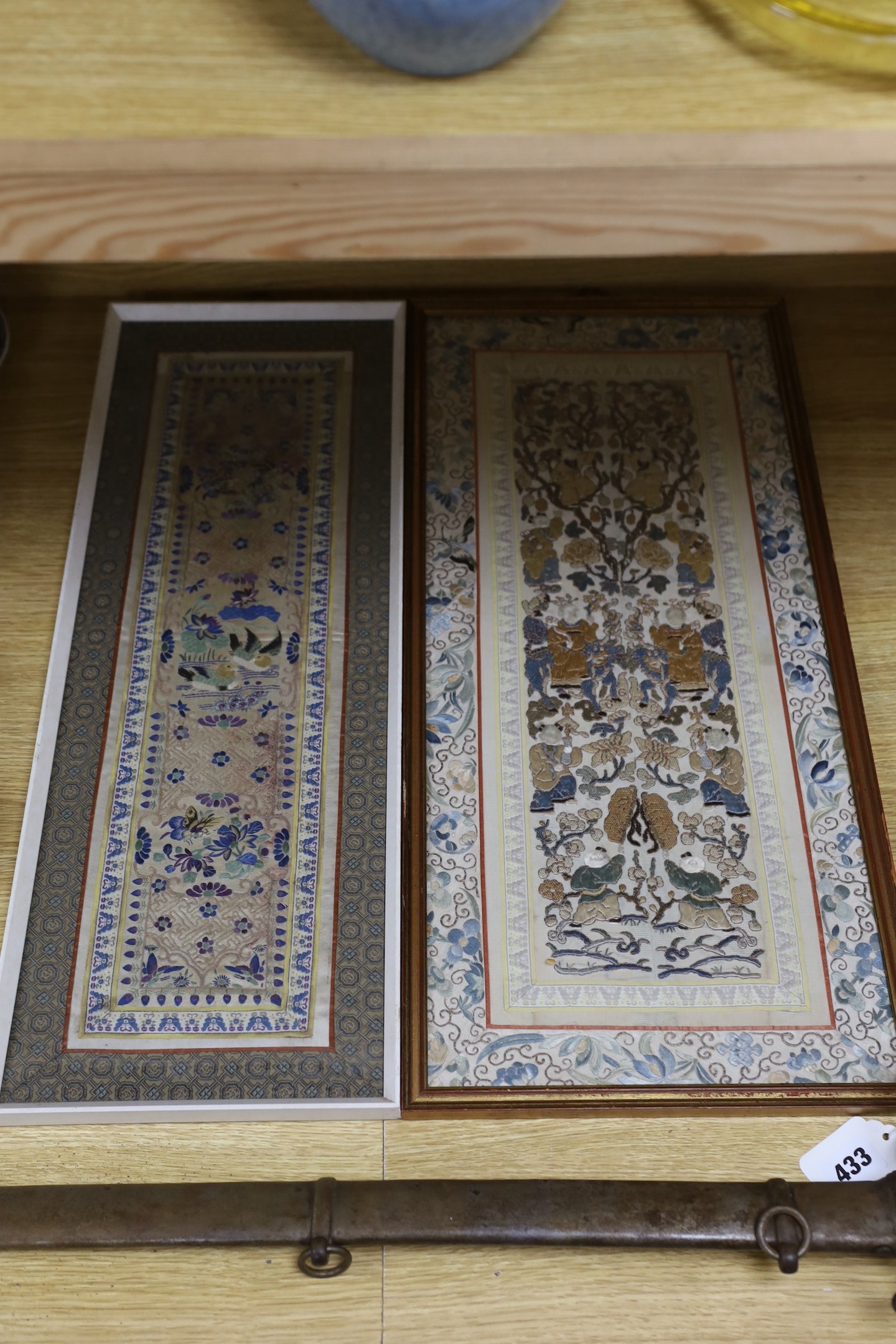 A framed pair of Chinese embroidered sleeve bands using Chinese knot and a another single framed sleeve band, pair 61.5 cms high x 26.5 wide.